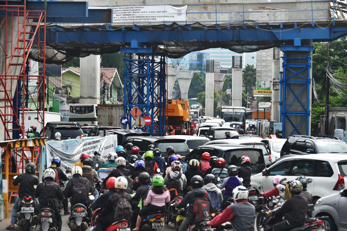 Motorists suffer through a traffic jam in Jakarta on February 4, 2016 near a construction site. Indonesia lacks a mass-transport system, forcing its increasingly affluent 260 million people to rely heavily on private transport. 
