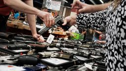 A woman tries a pistol at a gun show where thousands of different weapons are displayed for sale on July 10, 2016 in Fort Worth, Texas.