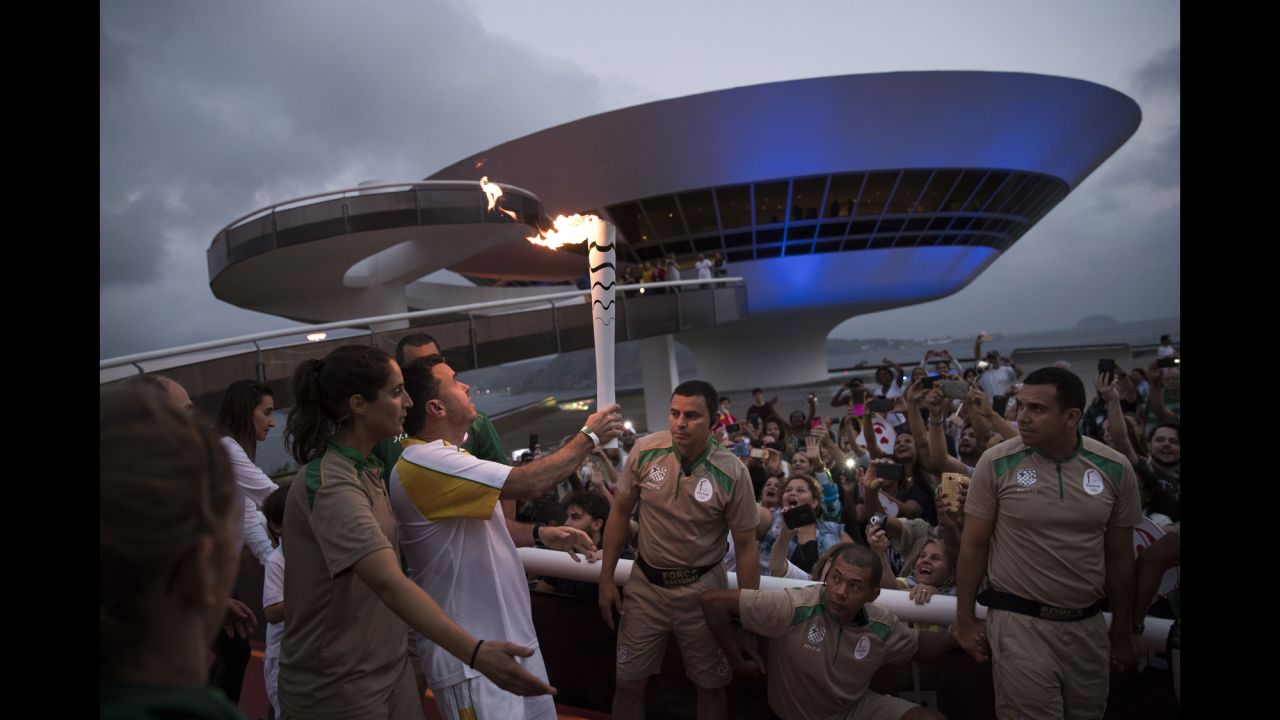 The Olympic torch is carried past the Contemporary Art Museum in Niteroi, Brazil, as it makes its way to Rio on Tuesday, August 2.