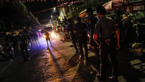 Police patrol a shanty community at night during curfew on June 8, 2016 in Manila. Philippine police have been conducting frequent night raids and revived a curfew for minors that has not been enforced for years.