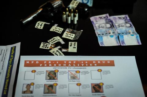 A gun, bullets, marked money and sachets of crystal meth are laid on a table after a drug raid  in Manila on June 20, 2016. 