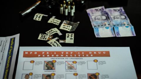 A gun, bullets, marked money and sachets of crystal meth are laid on a table after a drug raid in Manila on June 20, 2016.