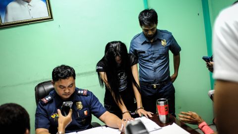A suspected female member of a drug syndicate is presented by police in Manila on June 22, 2016.
