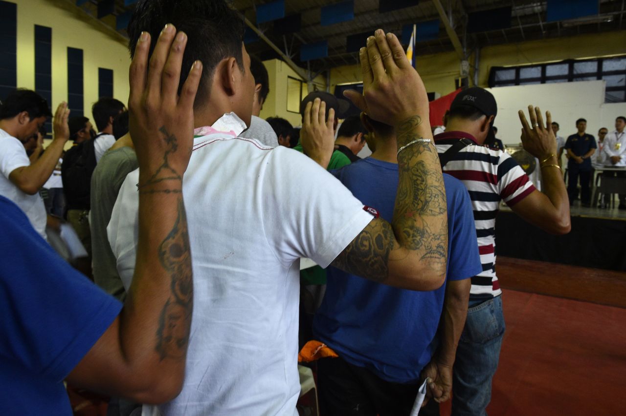 Some 1,000 people whom authorities accused of being drug users and dealers take an oath before local authorities after turning themselves in in Tanauan, the Philippines, on July 18, 2016. 