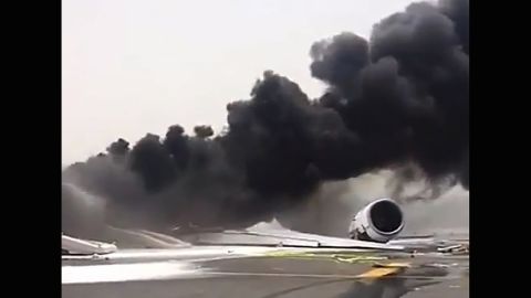 Dark smoke billows from the Emirates plane at Dubai International Airport.