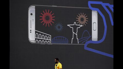 A volunteer walks past an advertisement in Rio's Olympic Park on August 3.