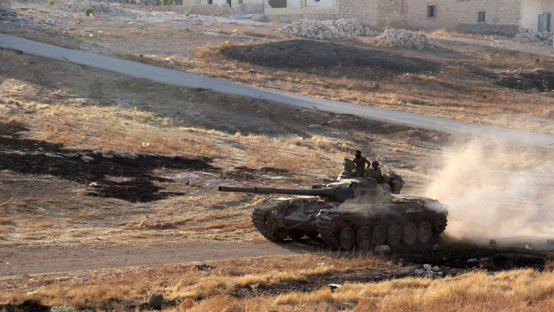 Opposition fighters drive a tank in the Al-Huweiz area on the southern fringe of Aleppo on August 2, 2016. 