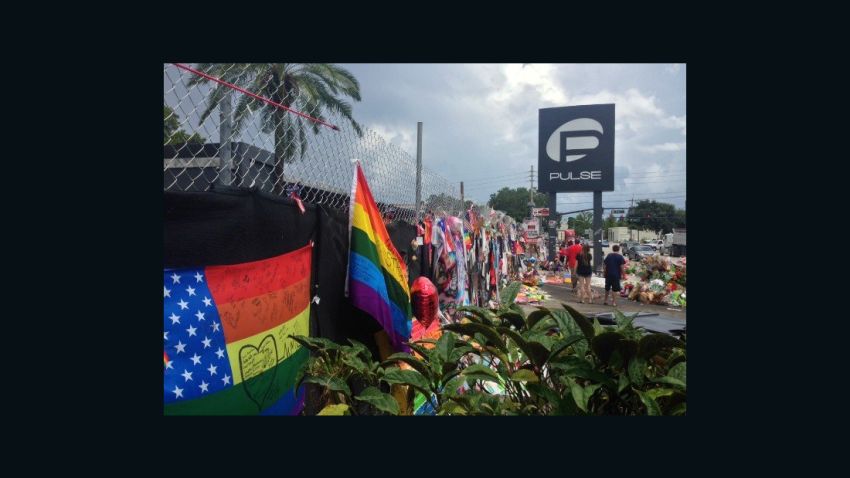 Mementos, flags, flowers and messages adorn a fence in front of Pulse nightclub south of downtown Orlando on Tuesday, July 19, 2016, more than a month after the deadly attack there.