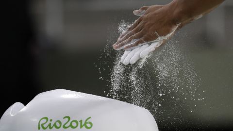 Cyprian gymnast Marios Georgiou rubs chalk on his hands before practicing on August 3. 