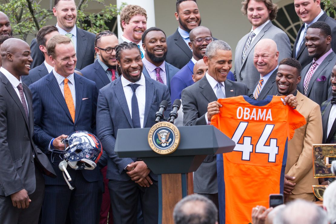 At June celebration   President Barack Obama lifts a Denver Broncos jersey her received in honor of the team's Super Bowl 50 victory over Carolina Panthers.