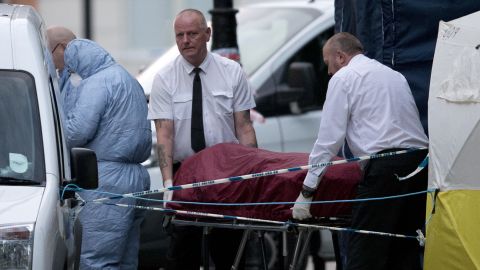 An ambulance crew removes a body from Russell Square early Thursday after a woman was killed.