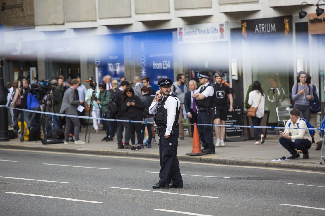 Journalists and others gather as police guard the attack scene Thursday in London's Russell Square.