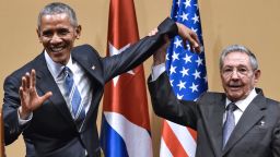 Cuban President Raul Castro (R) raises US President Barack Obama's hand during a meeting at the Revolution Palace in Havana on March 21, 2016. Cuba's Communist President Raul Castro on Monday stood next to Barack Obama and hailed his opposition to a long-standing economic "blockade," but said it would need to end before ties are fully normalized.