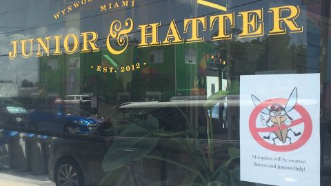 Jill Palma says people in Miami's Wynwood district are taking warnings about Zika in stride. A cartoon banning mosquitoes is now taped to the window of the salon she manages.