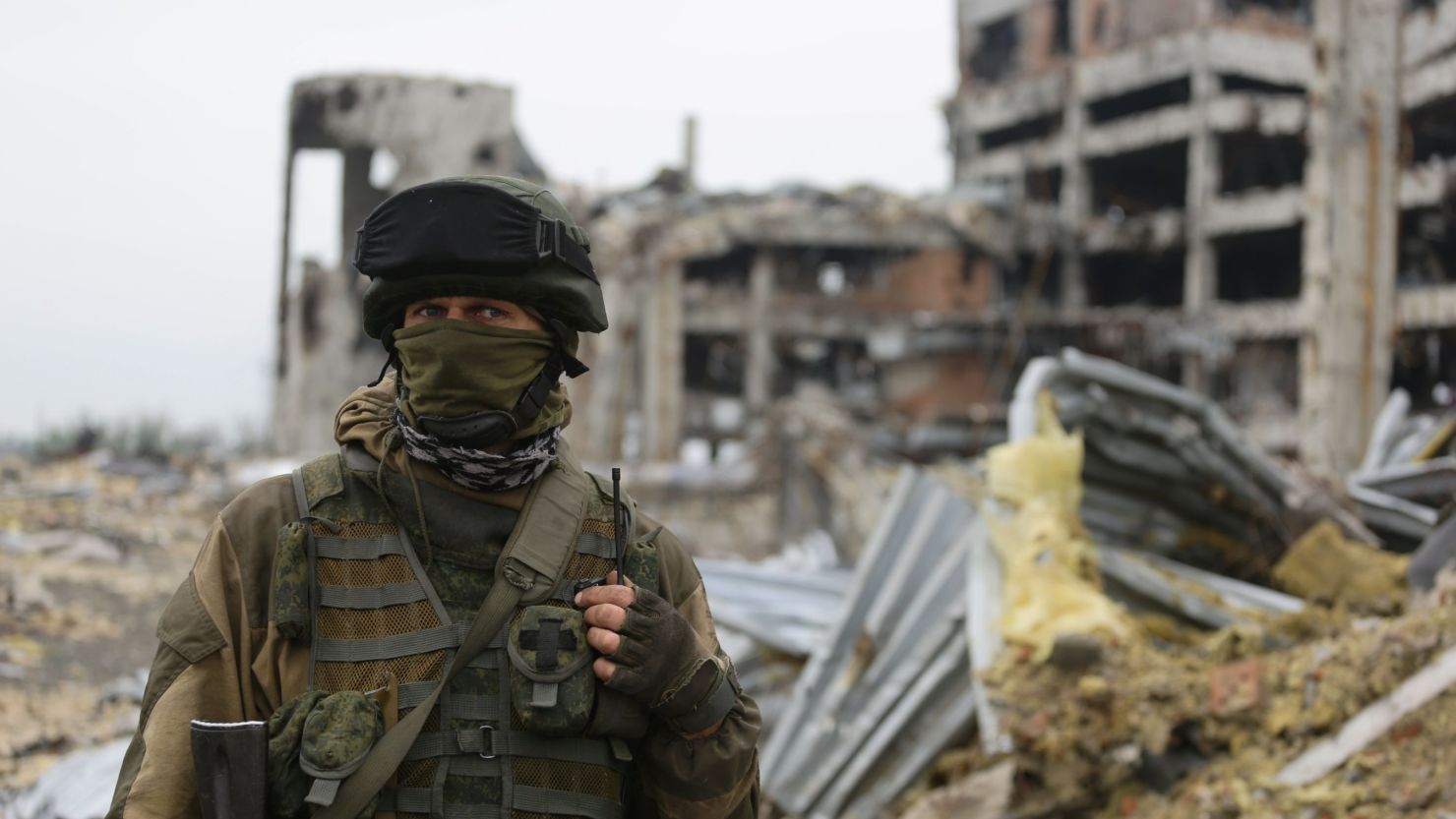 An armed pro-Russian separatist of the self-proclaimed Donetsk People's Republic (DNR) stands in front of the destroyed Donetsk International Airport, in Donetsk.