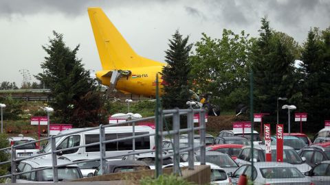 The DHL courier company's Boeing 737-400 cargo aircraft rests on a road after it came off the runway during landing at airport of Bergamo Orio al Serio, Italy, on Friday, August 5.
