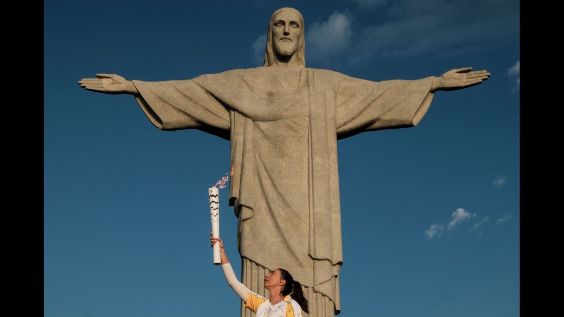 Retired Brazilian volleyball player Maria Isabel Barroso Salgado carries the Olympic torch in front of the Christ the Redeemer statue in Rio de Janeiro on Friday, August 5. The opening ceremony will be held at the Maracana Stadium on Friday night.