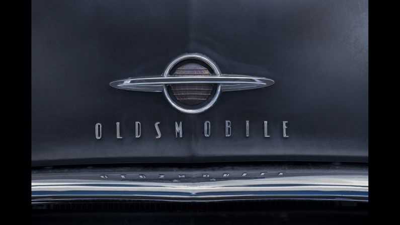 An Oldsmobile logo and typeface on the hood of a 1954 model