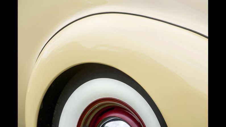 A rear quarter of a 1938 Packard Opera Coup, including part of the white wall tire, red wheel and hubcap