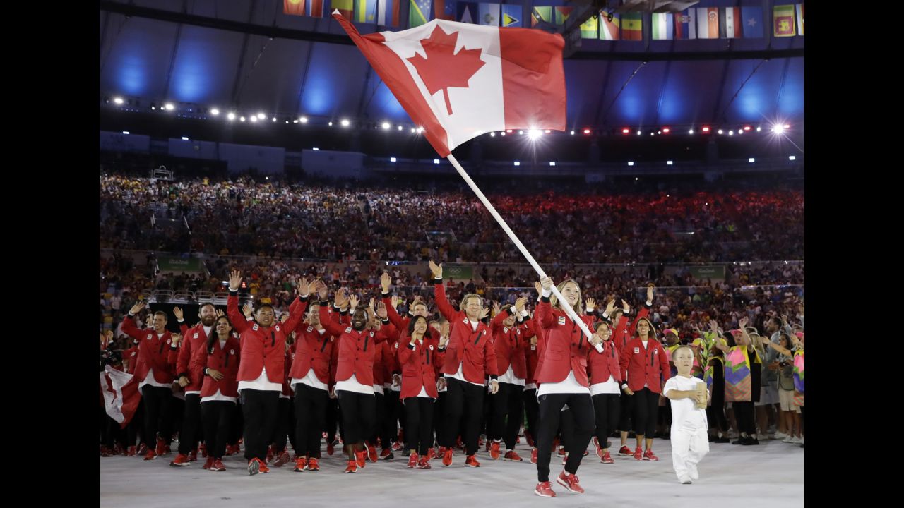 Trampoline gymnast Rosie MacLennan carries the Canadian flag.