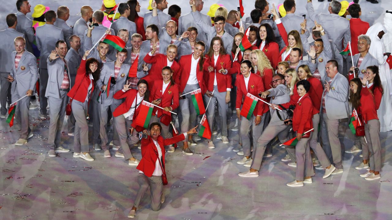 Belarus team members pose for photographs while entering the stadium.