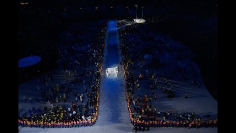 The Olympic flag is carried into the stadium.