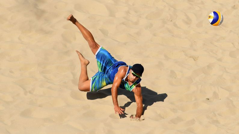 Bruno Schmidt of Brazil dives for the ball during the men's beach volleyball preliminary round Pool A match against Josh Binstock and Sam Schachter of Canada.