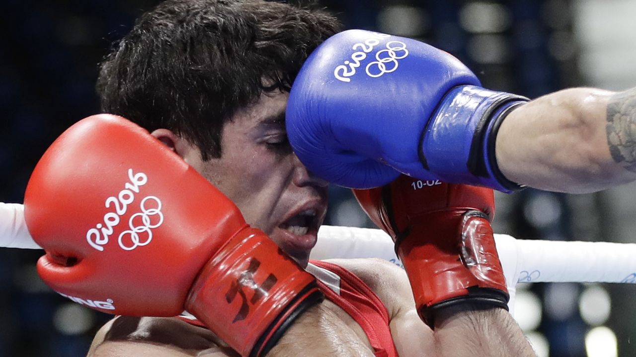 Armenia's Artur Hovhannisyan receives a punch from Spain's Samuel Carmona Heredia during a men's light flyweight 49-kg preliminary boxing match. Hovhannisyan lost the match 0-3.
