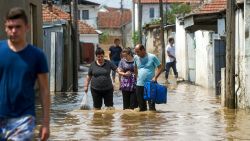 People wade through floodwaters on Sunday in the village of Stajkovci, near Skopje, Macedonia.