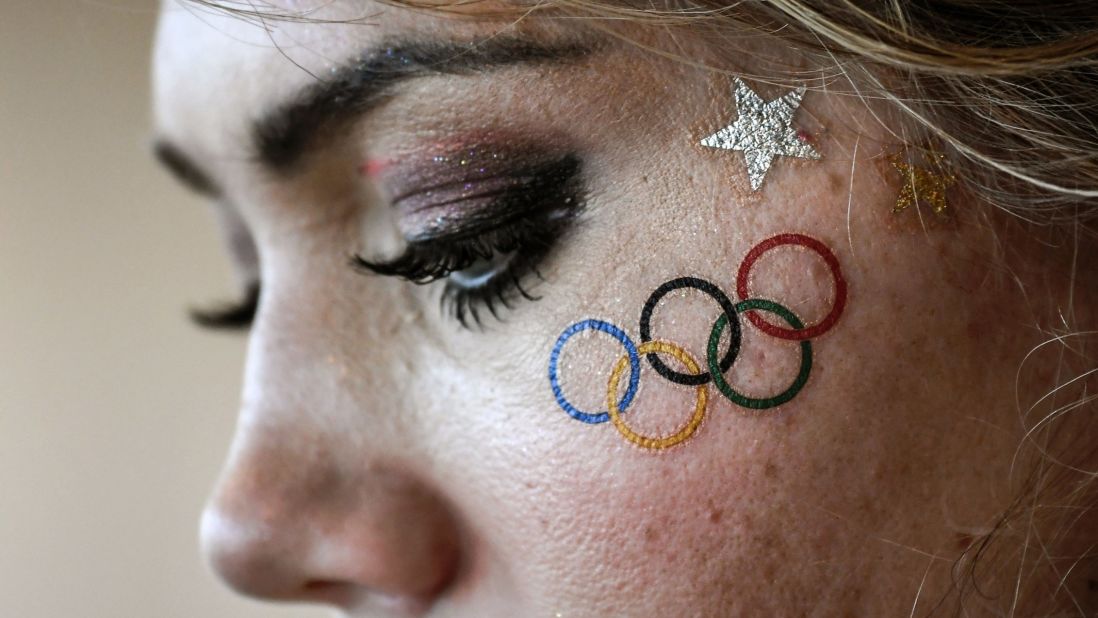 A volunteer wearing a temporary tattoo of the Olympic rings waits for the start of competition after the rowing event was delayed. Later the official governing body for world rowing confirmed that all races were canceled Sunday due to high winds and choppy waters at Lagoa.