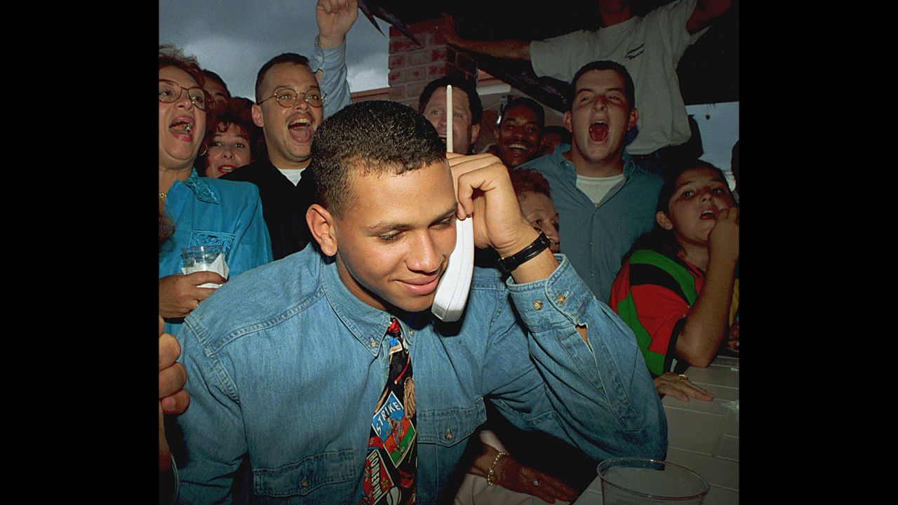 Alex Rodriguez listens on the telephone as the Seattle Mariners ask him to join their team amid cheers from his mother, Lourdes, back left, and friends in Miami, Florida, on June 3, 1993.  Rodriguez, then 18, was the top draft choice in baseball's amateur draft.