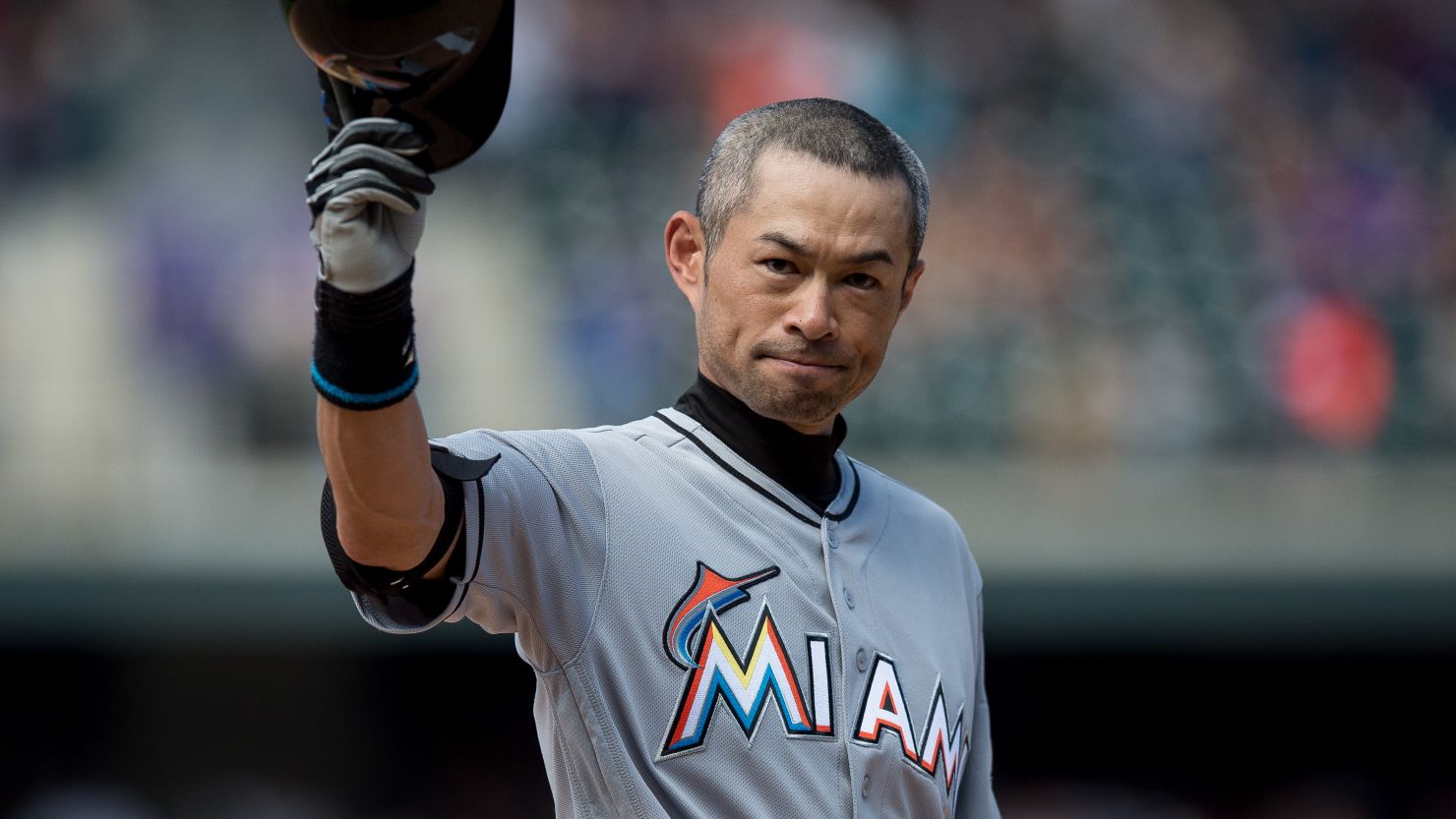 Ichiro Suzuki of the Miami Marlins tips his hat to the crowd after hitting a seventh inning triple against the Colorado Rockies for the 3,000th hit of his MLB career.