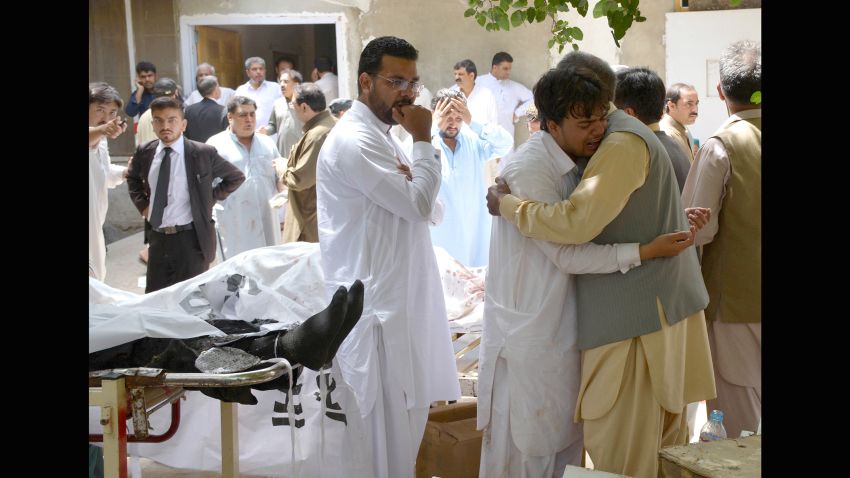 People react beside the bodies of victims following a bomb explosion at a government hospital in Quetta, Pakistan, on Monday, August 8.
