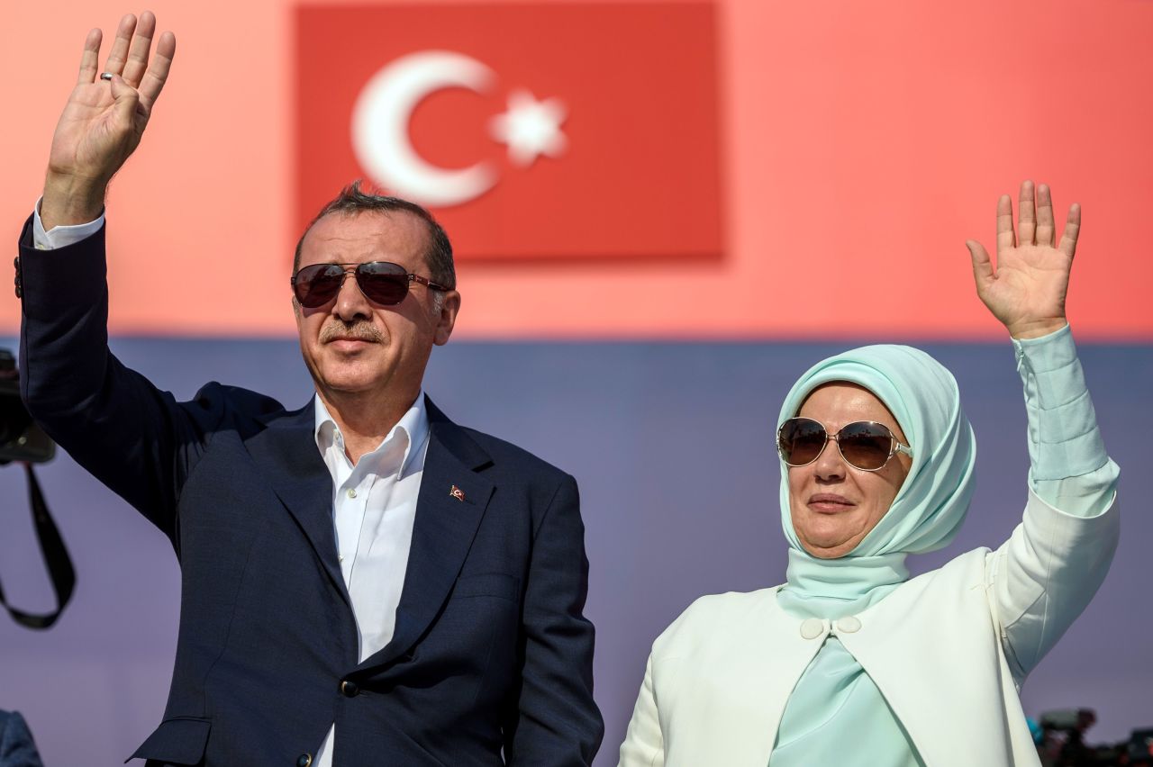 Erdogan (L) an his wife Emine Erdogan (R) wave at supporters at the rally.