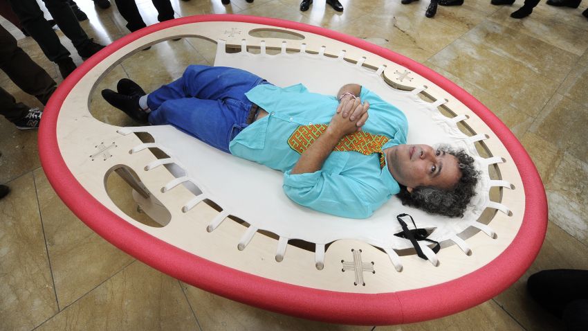 Brazilian artist Ernesto Neto lies on his artwork "Looking at the Sky" as he looks at his installation "The Falling Body" (out of frame) during the presentation of his exhibition "The Body That Carries Me" on February 13, 2014 at the Guggenheim Bilbao museum in the northern Spanish Basque city of Bilbao.  AFP PHOTO / RAFA RIVAS        (Photo credit should read RAFA RIVAS/AFP/Getty Images)