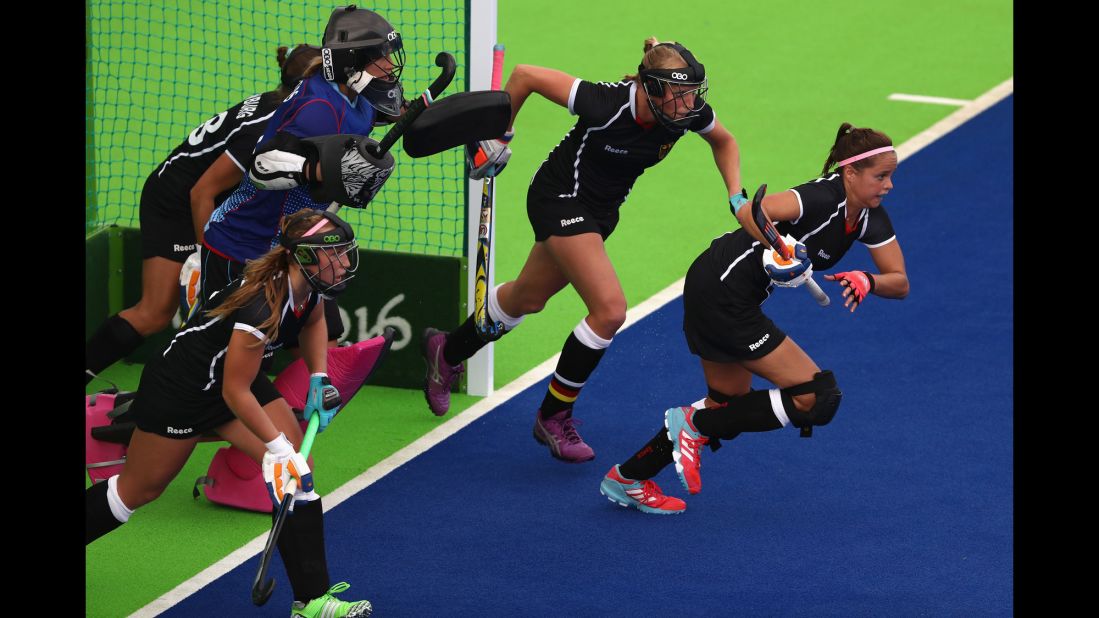 German field hockey players run from goal during a match against New Zealand.