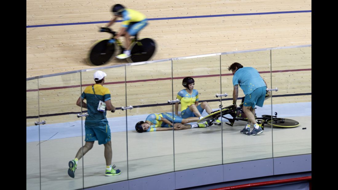 Australian cyclist Melissa Hoskins, center left, lies on the track after the pursuit team crashed during a training session. She was taken to the hospital.