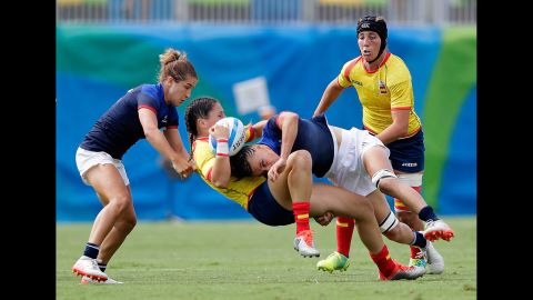 Amaia Erbina of Spain is tackled by Audrey Amiel and Pauline Biscarat of France during a rugby sevens match.