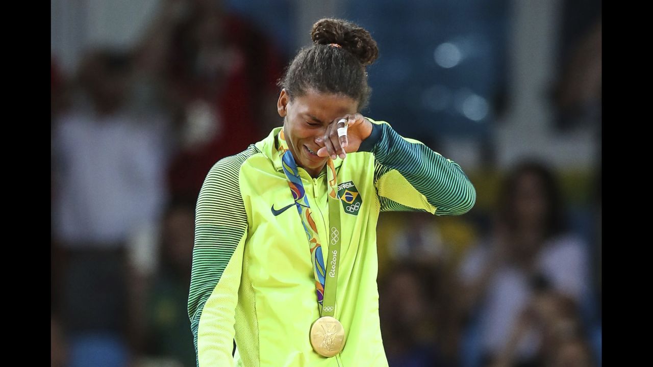 Judoka Rafaela Silva cries on the medal stand after she won Brazil's first gold at the Rio Games. She defeated Dorjsurengiin Sumiyaa in the final of the 57-kilogram weight class.