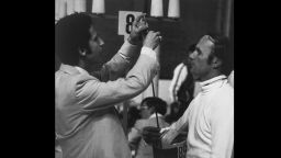 A judge checks the weapon of Soviet pentathlete Boris Onischenko.