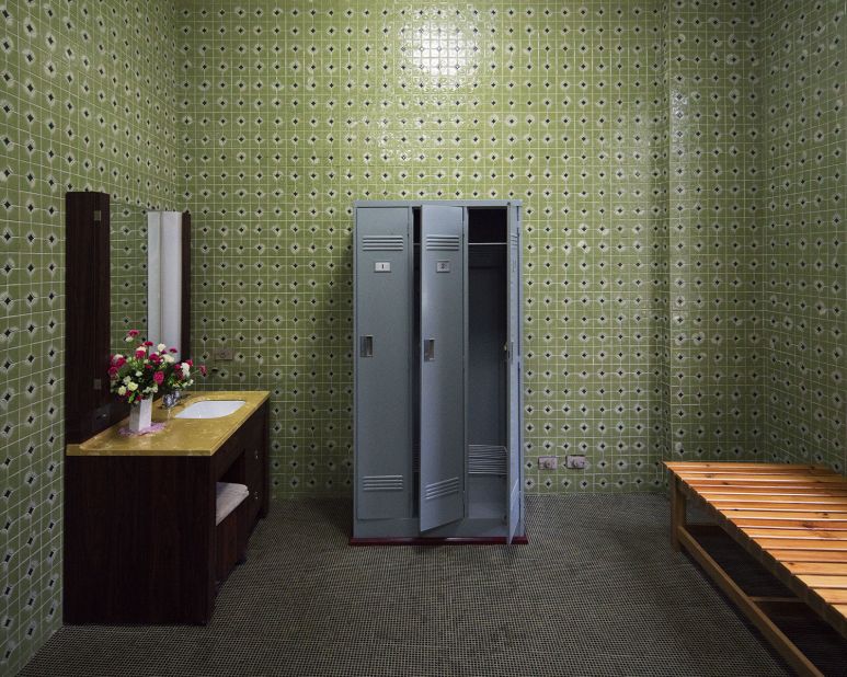 "Dressing room of a private sauna at the Changgwang-won health complex, featuring beautiful green tile work with black floor, matching the unique vintage tones of the city."