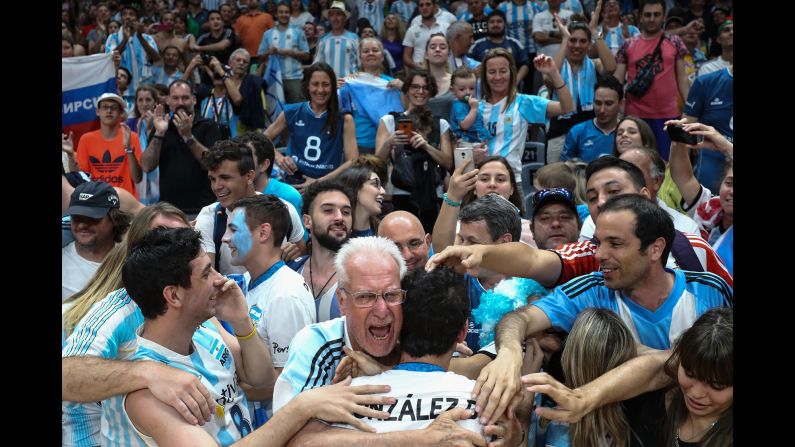 Volleyball player Demian Gonzalez is embraced by Argentina fans after his team beat Russia in a preliminary round. They will next face Poland on Thursday.