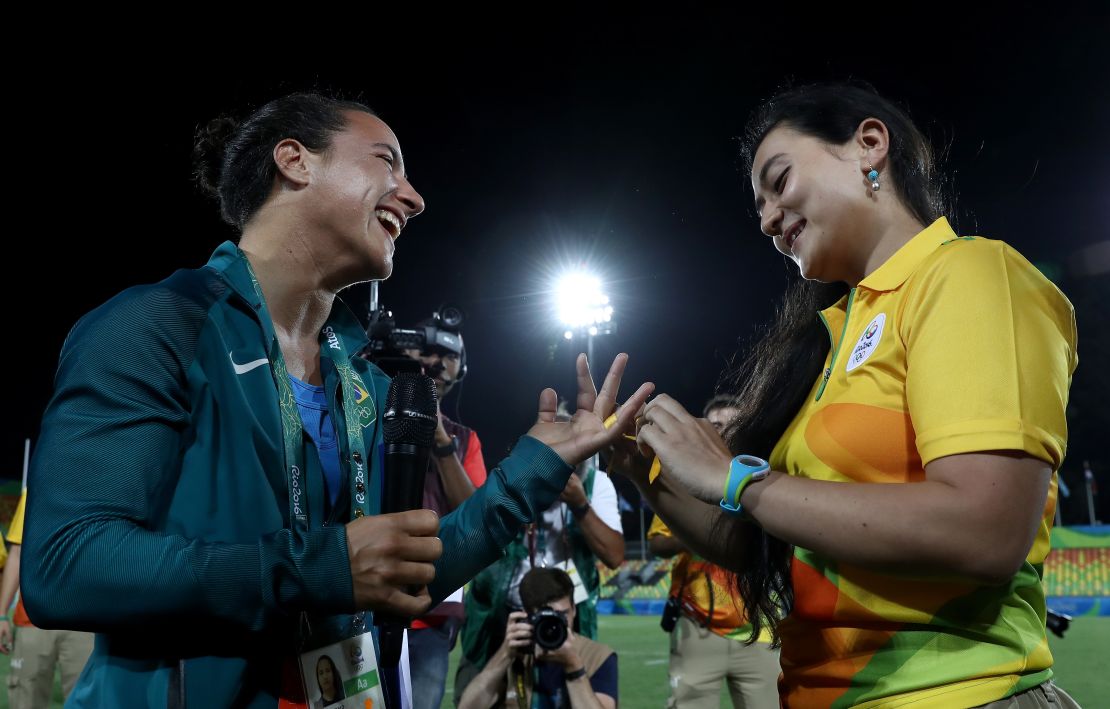 Enya, right, ties a ribbon around Cerullo's finger. 