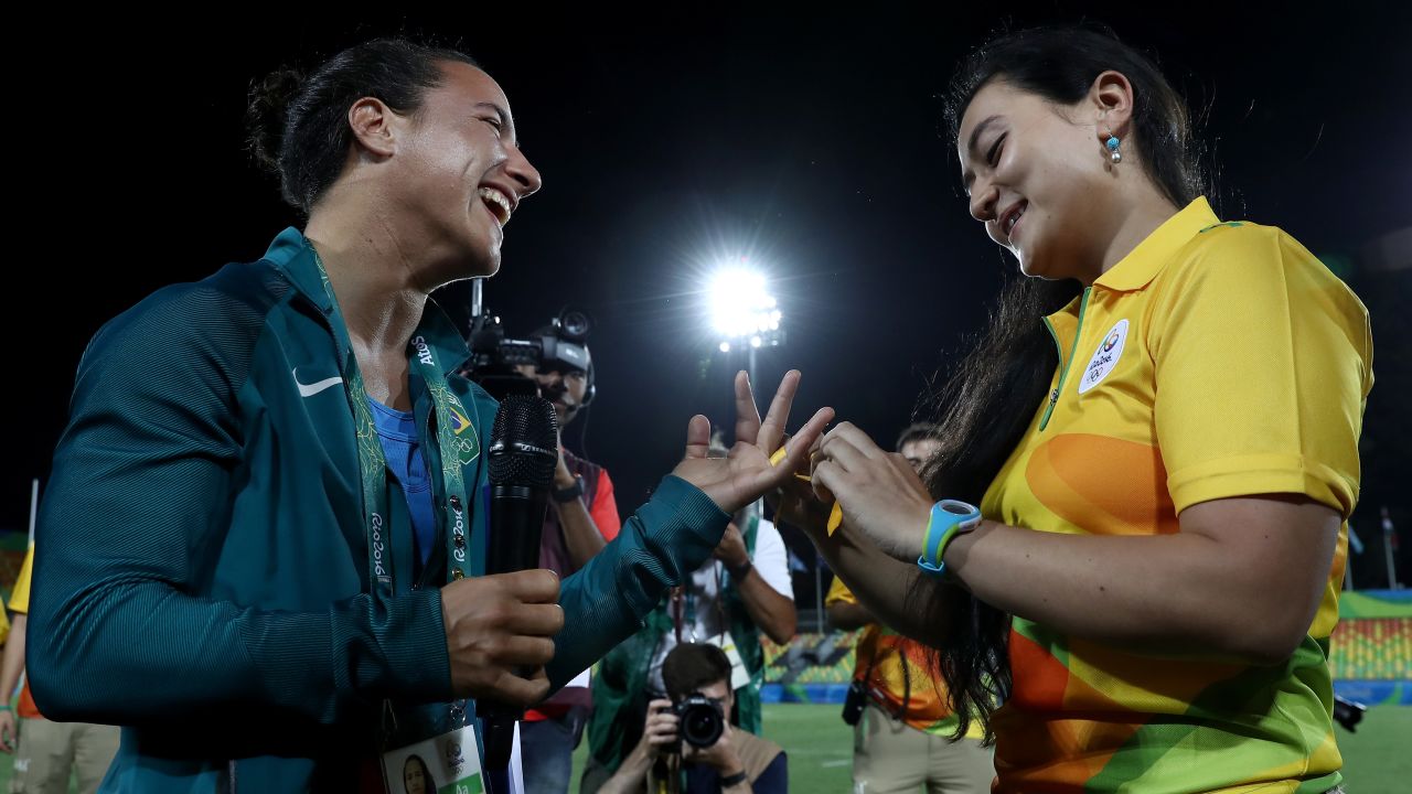 Enya, right, ties a ribbon around Cerullo's finger.