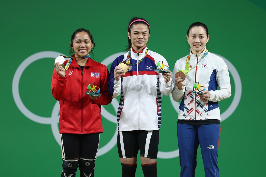 Hsu Shu-ching (middle) holds her gold medal alongside silver medalist Hidilyn Diaz of the Philippines and bronze medalist Jin Hee Yoon of South Korea.