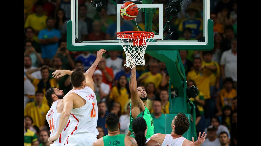Brazilian basketball player Marcus Marquinhos, in green under the basket, tips in the winning basket to upset Spain 66-65.