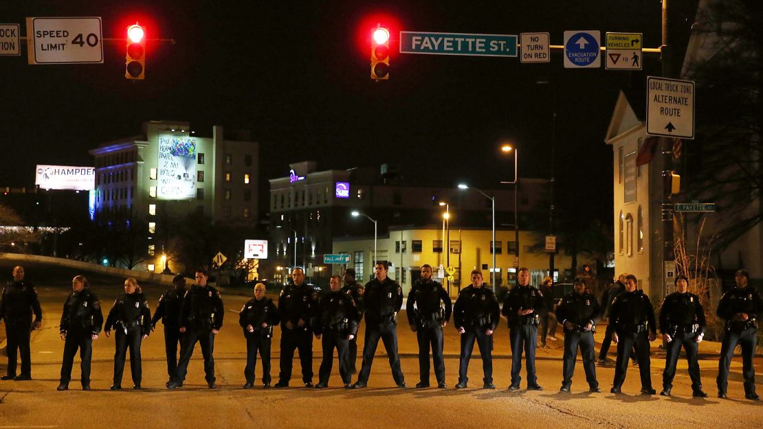 Police stand guard as protesters march in 2015 following a mistrial declared in the trial of an officer charged in Freddie Gray's death.