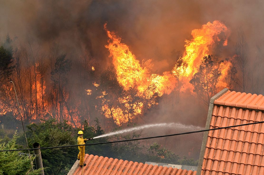 A firefighter works to extinguish a fire at a home in Funchal.