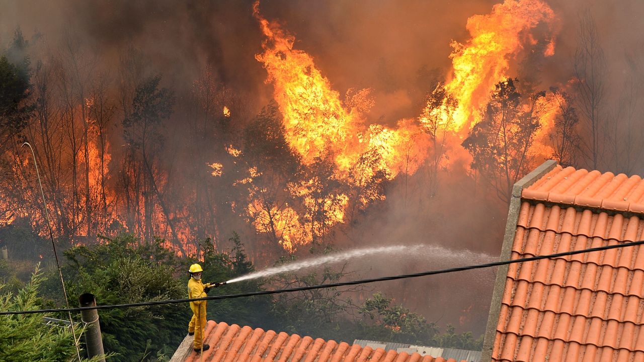 A firefighter works to extinguish a fire at a home in Funchal.