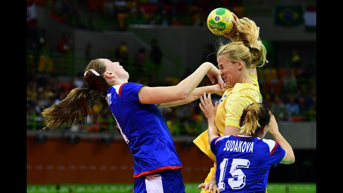 Russian handball player Victoria Zhilinskayte, left, competes against Sweden's Linnea Torstensson during a preliminary match.